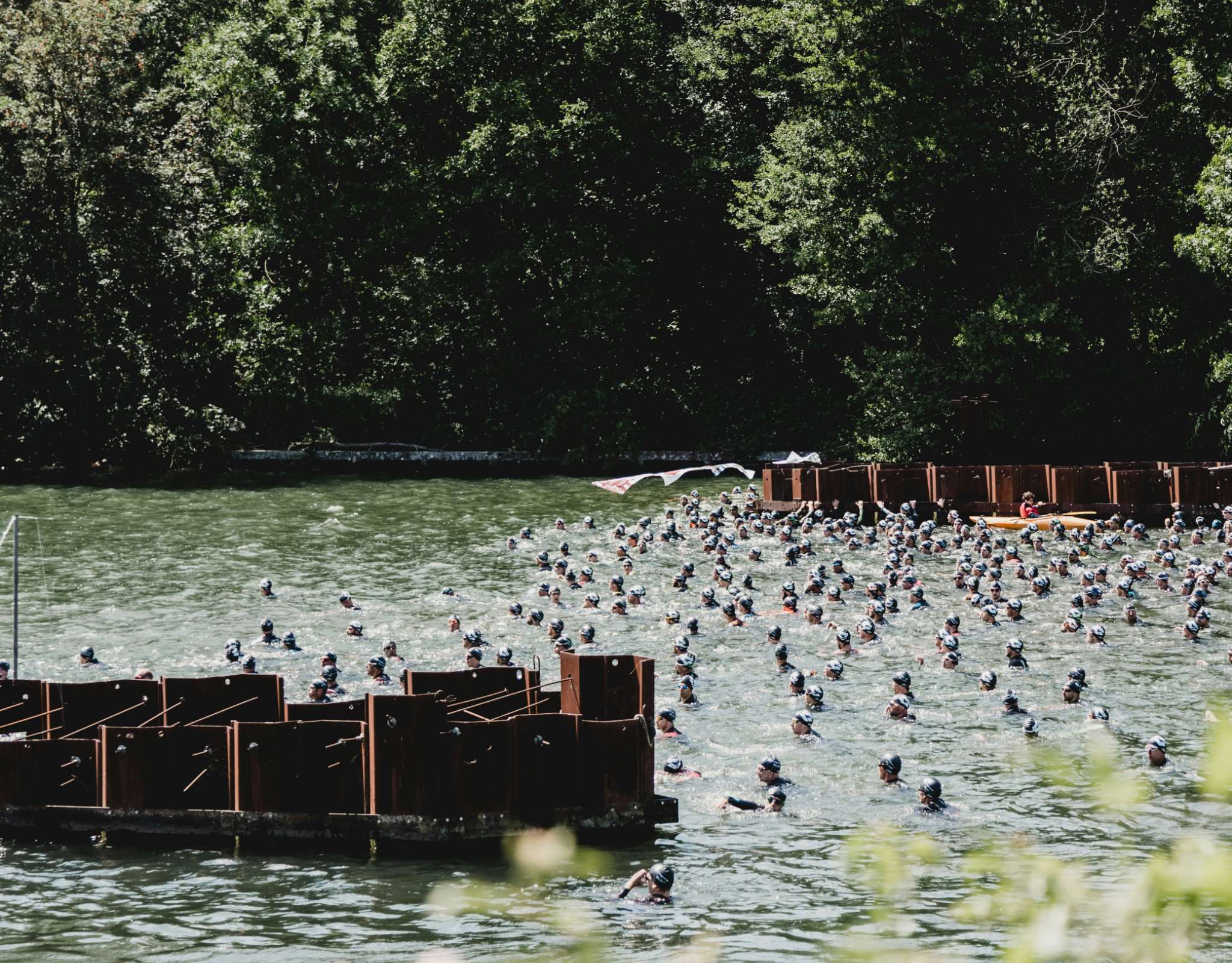 Grand groupe de nageurs en eau libre rassemblés à la zone de départ.