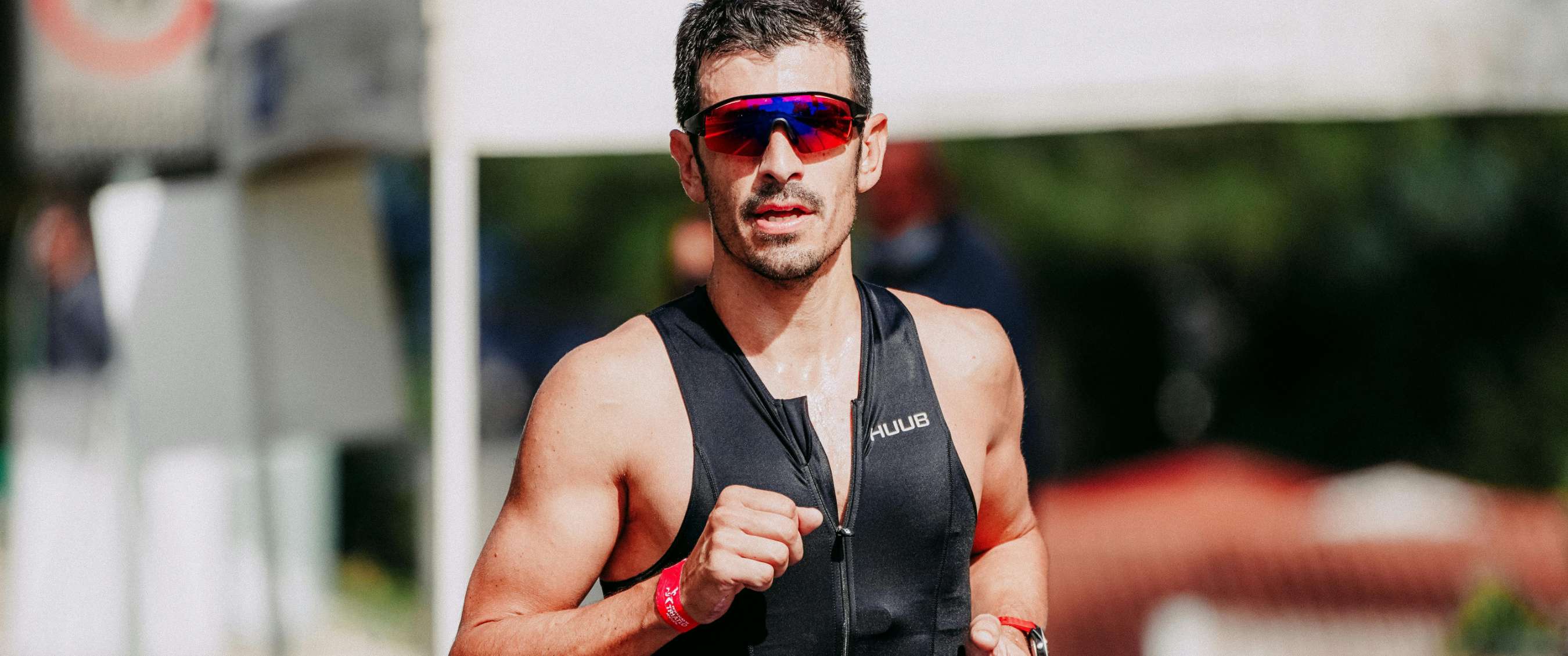 Gros plan d’un coureur portant des lunettes de sport en compétition.