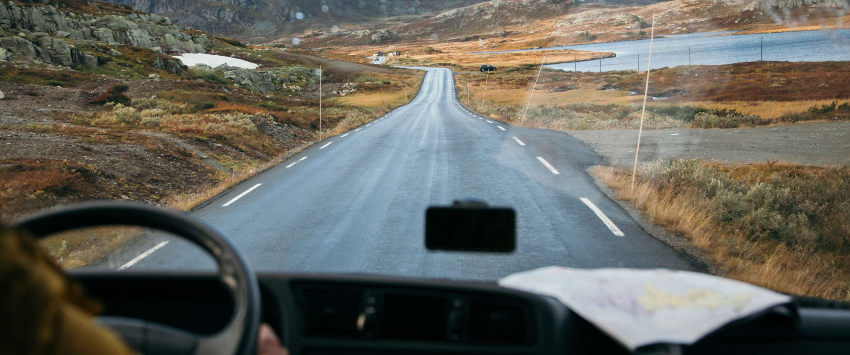 Vue depuis un véhicule sur une route vide à travers un paysage montagneux